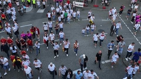 Stor publik rör sig över en avspärrad stadsgata vid ett evenemang