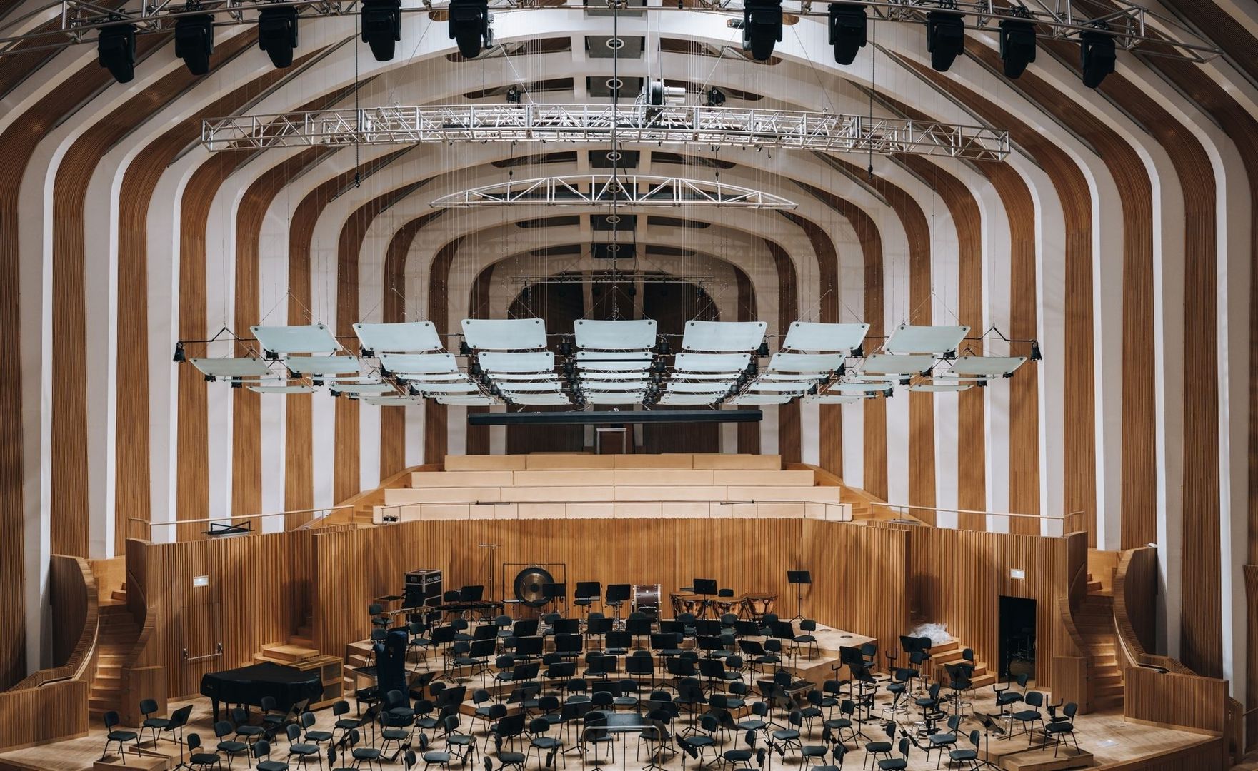 Konsertsal med orkesterscen och nedhängda akustikpaneler i taket